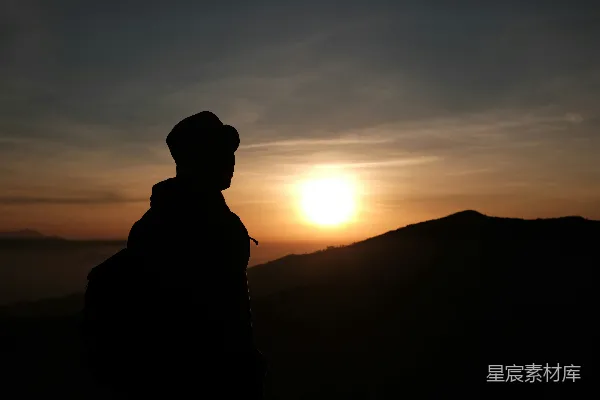 高清摄影 在日落时站在山上的男人剪影