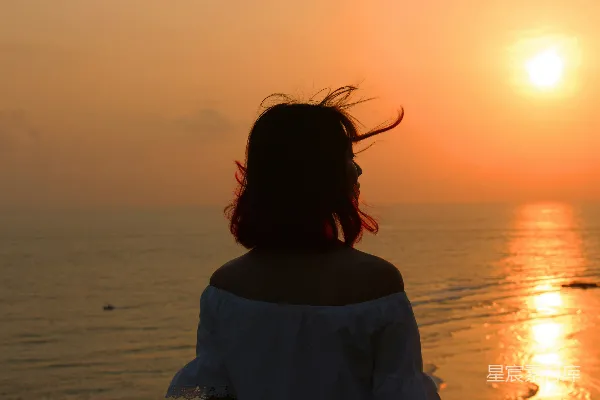 高清摄影 穿着白色衬衫的女人站在海滩上，夕阳西下。