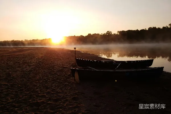 高清摄影 棕色的船停泊在棕色的沙滩上，夕阳西下。