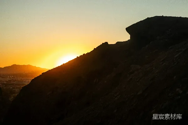 高清摄影 夕阳正照耀着一座岩石山巅。