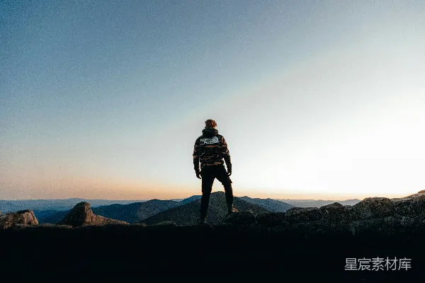高清摄影 身穿黑色夹克的男人站在白天的山顶上。