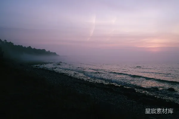 高清摄影 夕阳西下，海滩雾蒙蒙，前景是浩瀚的海洋。