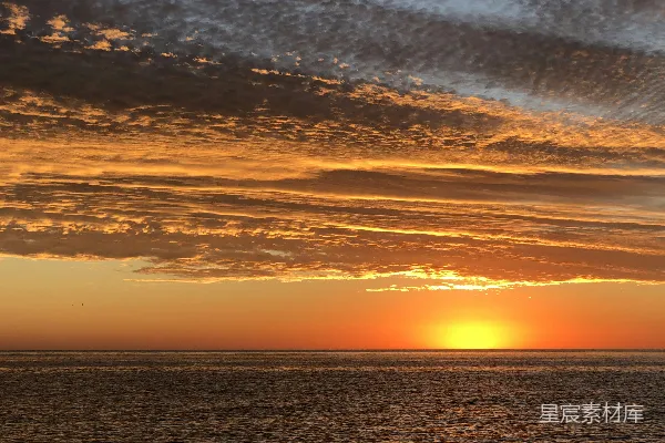 高清摄影 夕阳正缓缓落下，海面上有一艘小船漂浮着。