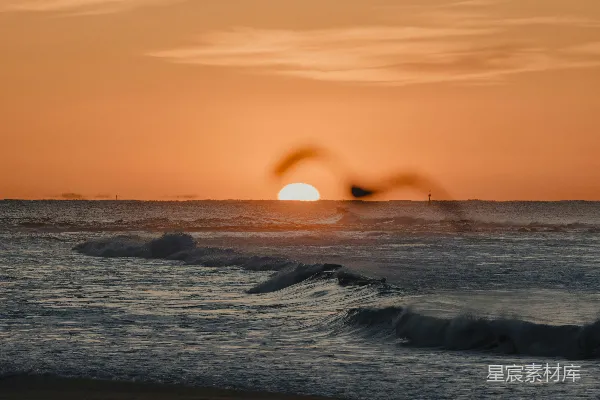 高清摄影 夕阳正在海洋上落下，海浪拍打着岸边。