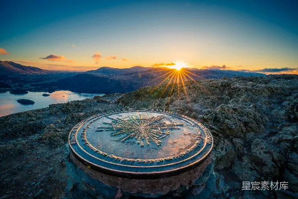 高清摄影 夕阳西下，山峰上有一个时钟。