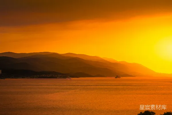 高清摄影 夕阳映照在水面上，背景是连绵的山脉。