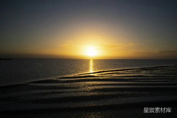 高清摄影 夕阳在海滩的水面上落下。