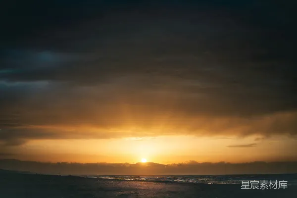 高清摄影 在多云的一天，太阳正缓缓落下海平面上方。
