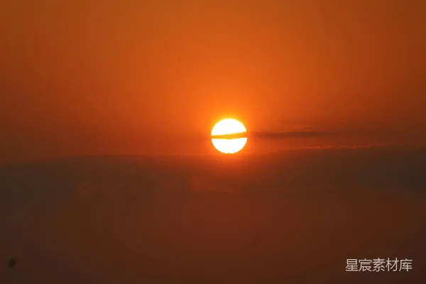 高清摄影 夕阳在橙色的天边，被薄雾笼罩的云层后落下。