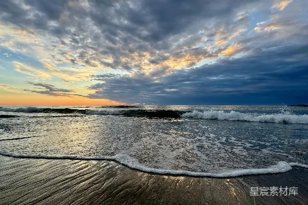 高清摄影 海浪在日落时拍打着沙滩。