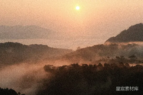 高清摄影 雾蒙蒙的群山和森林树冠上的日出。