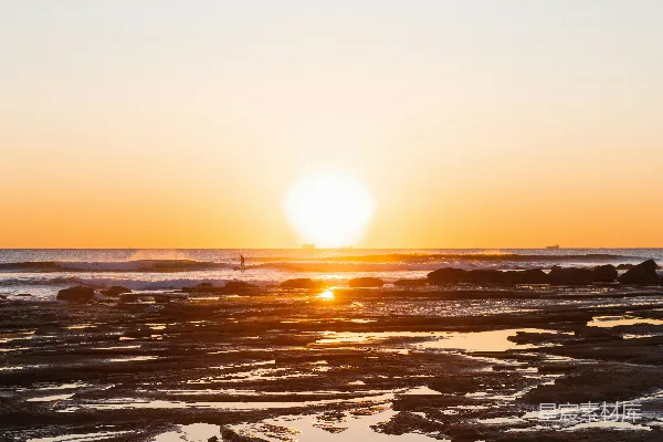 高清摄影 夕阳正挂在水面上的海滩上。