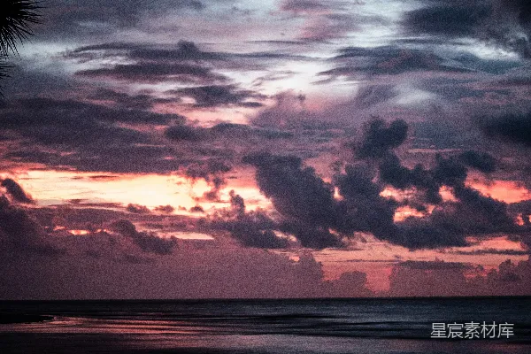 高清摄影 夕阳正洒落在海洋之上，天空中有云彩漂浮着。