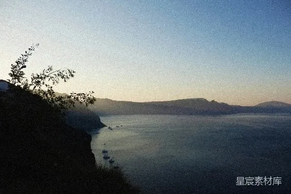 高清摄影 一个有树木环绕的水域，其中停泊着船只。
