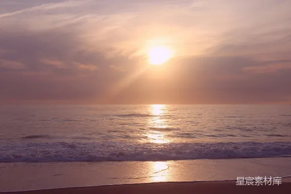 高清摄影 夕阳正洒落在海滩上的海洋上。