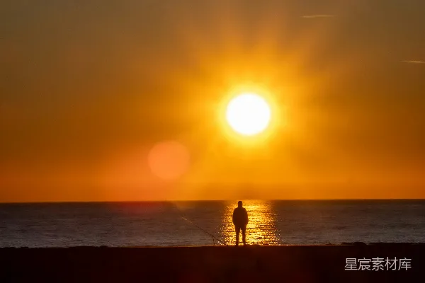 高清摄影 一个人的剪影，站在海边，凝视着夕阳。