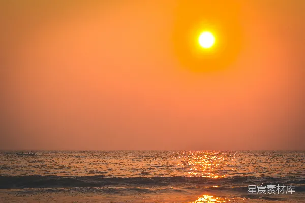 高清摄影 夕阳正缓缓落下，海面波光粼粼，远处有一艘小船。