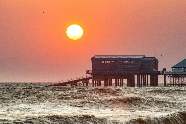 高清摄影 摩天大楼在海浪中夕阳下。