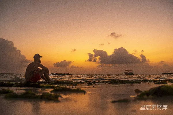 高清摄影 夕阳下坐在岸边的男人剪影