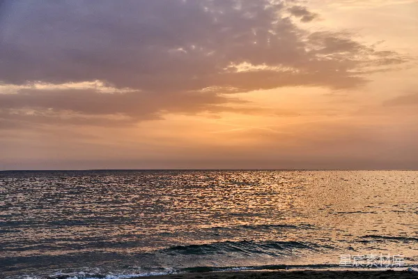 高清摄影 夕阳西下，平静的海面上漂浮着色彩斑斓的云朵。