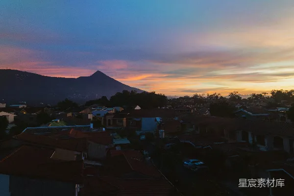 高清摄影 夕阳下的城市景观，背景中有山脉。