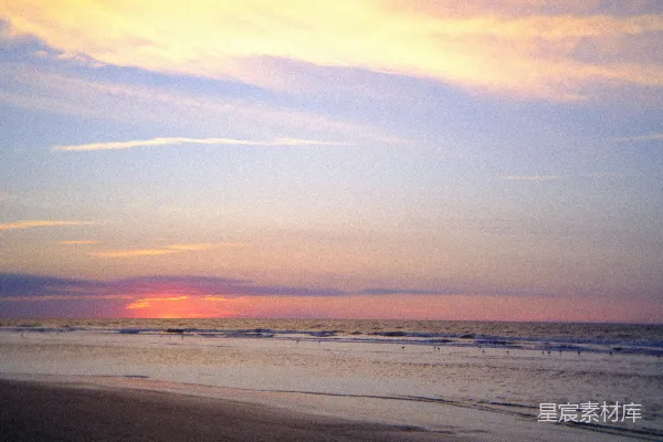 高清摄影 夕阳正落向大海，海滩上景色如画。