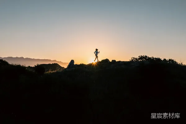 高清摄影 一个人站在山顶上，夕阳西下。