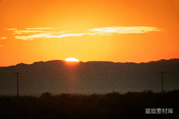 高清摄影 夕阳映照在剪影山峦上的电线杆上