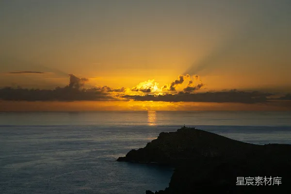 高清摄影 夕阳正落下，云朵漂浮在海面上。