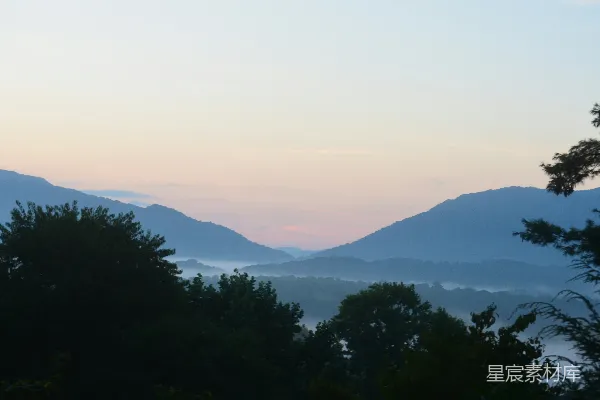 高清摄影 一座山脉的景观，前景中有树木。