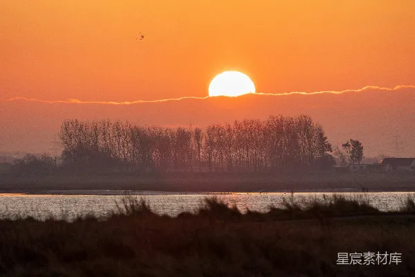 高清摄影 夕阳正沉落在一片水域之上。
