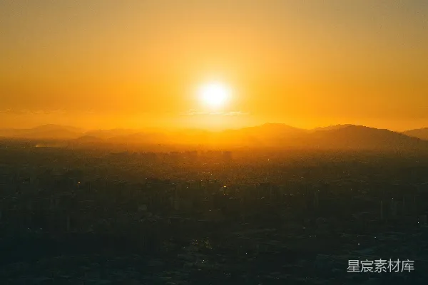 高清摄影 夕阳西下，城市远景中耸立着连绵的山脉。