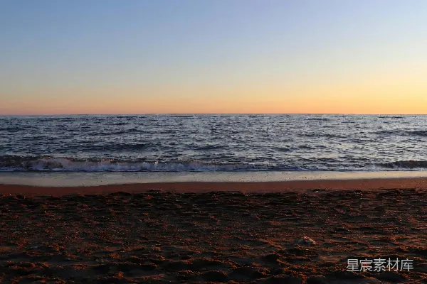 高清摄影 夕阳下，沙滩上波澜宁静的海浪