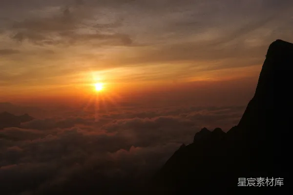 高清摄影 云层之上日出，山的轮廓清晰可见