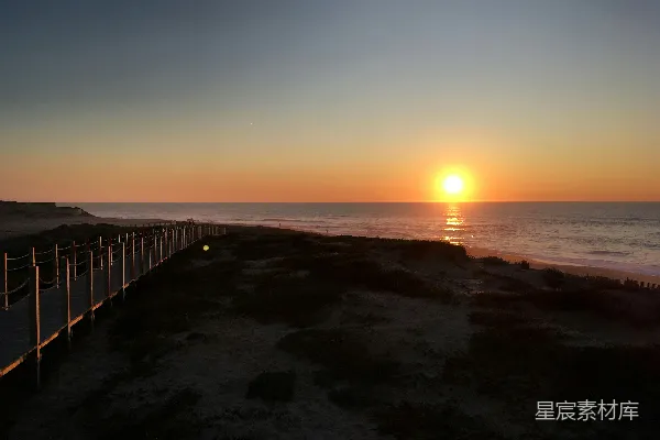 高清摄影 夕阳西下，海面上有一条栈道。