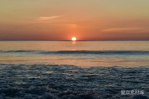 高清摄影 夕阳正落于海面，海滩上一片宁静。