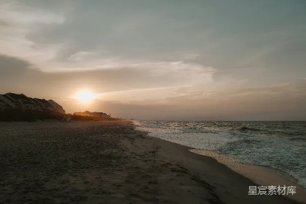高清摄影 夕阳正在海面上落下，海滩上一片宁静。