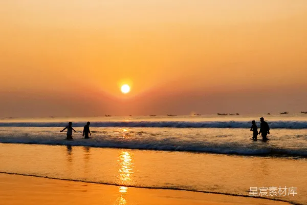 高清摄影 人们在绚丽的夕阳下漫步在海滩上。