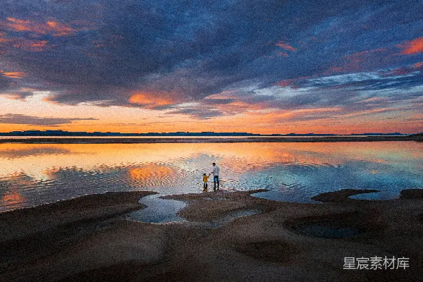 高清摄影 两个人站在水中，夕阳西下。
