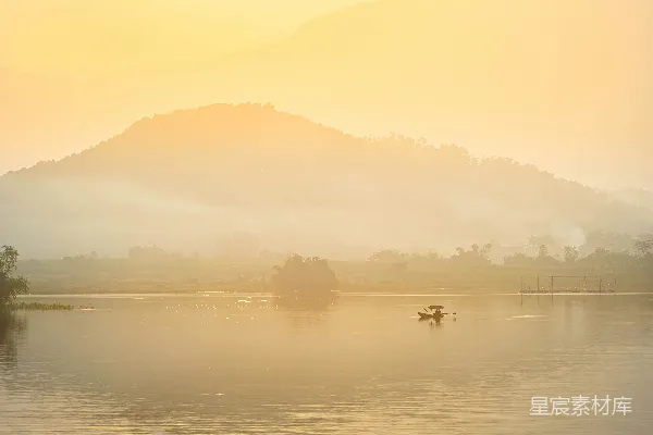高清摄影 一艘船在平静的湖面上，夕阳下群山环绕。