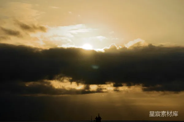 高清摄影 夕阳正照耀在海面上，远处有一艘小船。