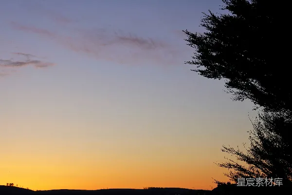 高清摄影 夕阳西下，天空中树木和山峦的剪影