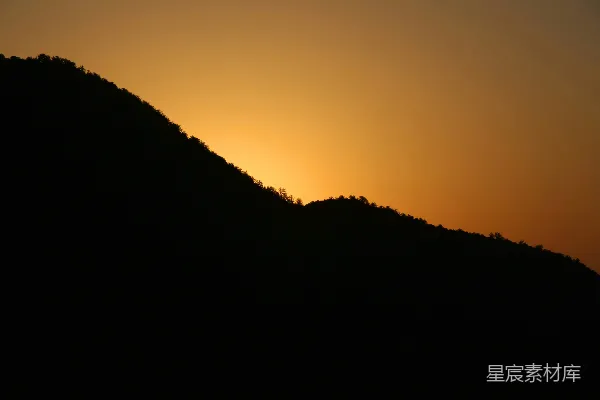 高清摄影 山的剪影映衬在温暖的夕阳天空下