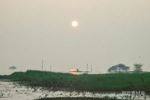 高清摄影 一片宽广的水域，天空中有一轮太阳。