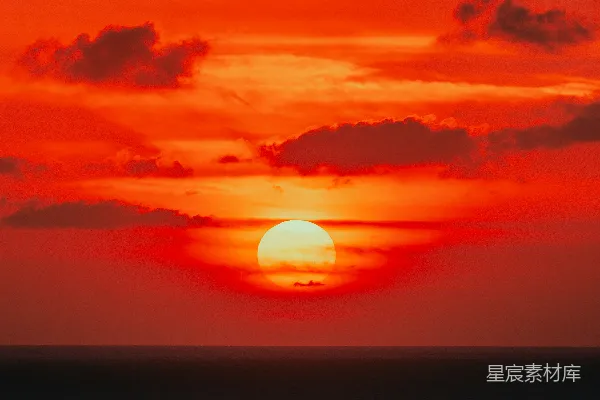高清摄影 在多云的日子里，太阳正缓缓沉入海平面。
