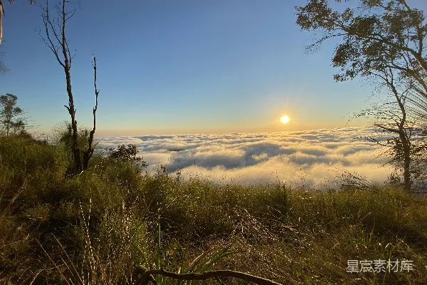 高清摄影 夕阳笼罩在群山间的云层之上。