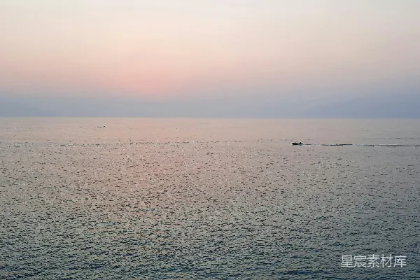 高清摄影 夕阳下，一艘小船在海面上航行。