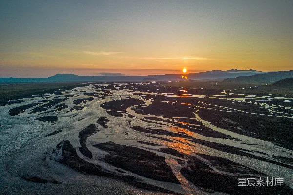 高清摄影 夕阳正挂在山脉中的一条河上。