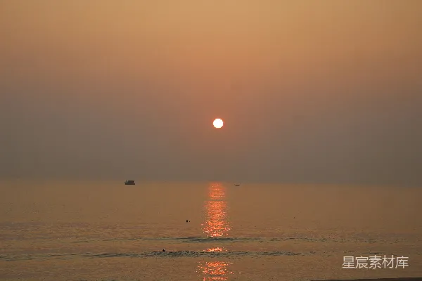 高清摄影 平静的海面上夕阳西下，一艘小船。