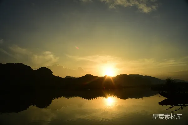 高清摄影 湖面平静，夕阳映照，远处山影轮廓清晰。